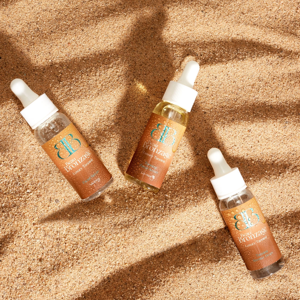 Beau Bronzage facial serums and drops: Beau Bronzage Face Drops with Hyaluronic Acid, tanning facial drops and tanning bronzing drops, photographed against a sand dune background