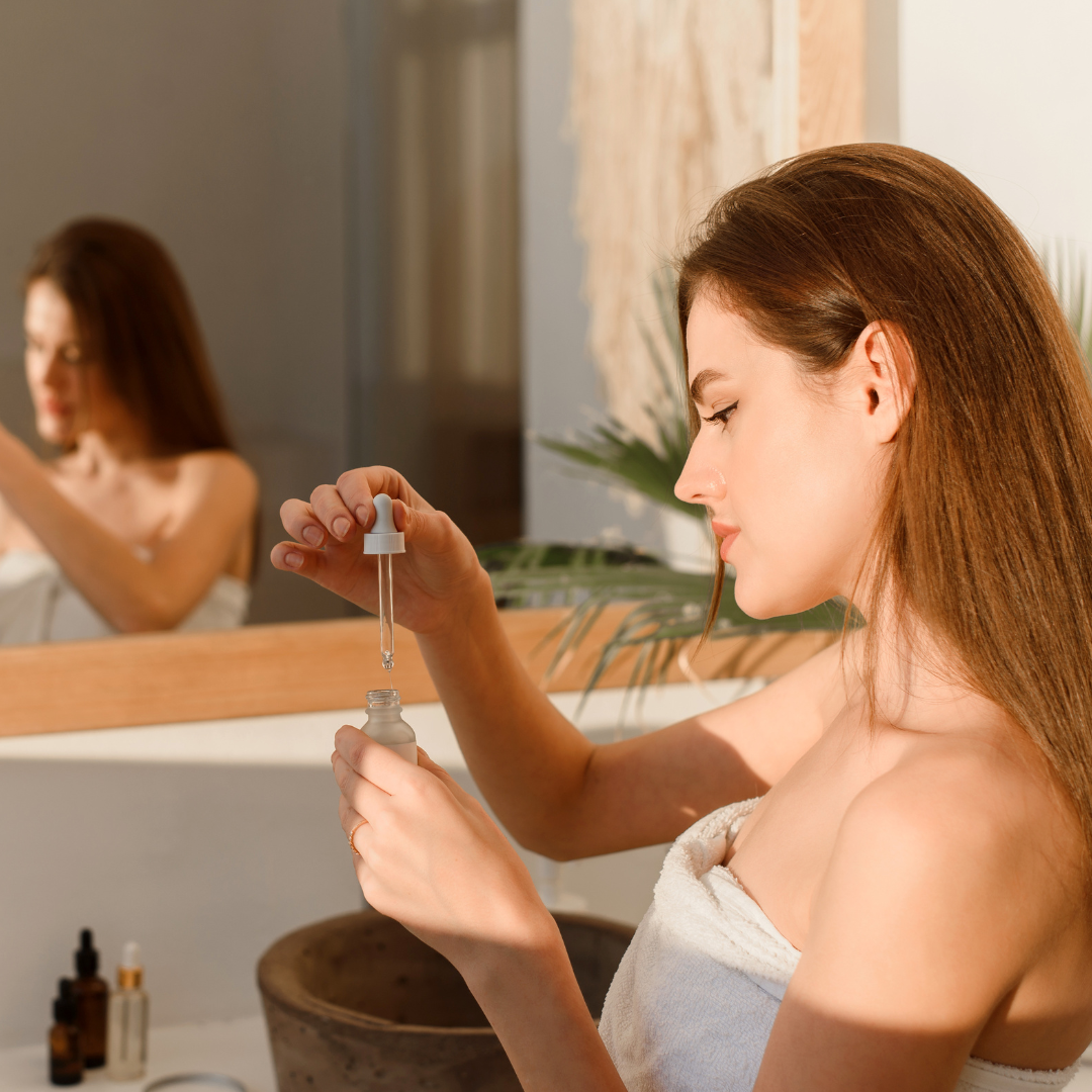 A young woman applying Tanning Bronzing Drops to her hand